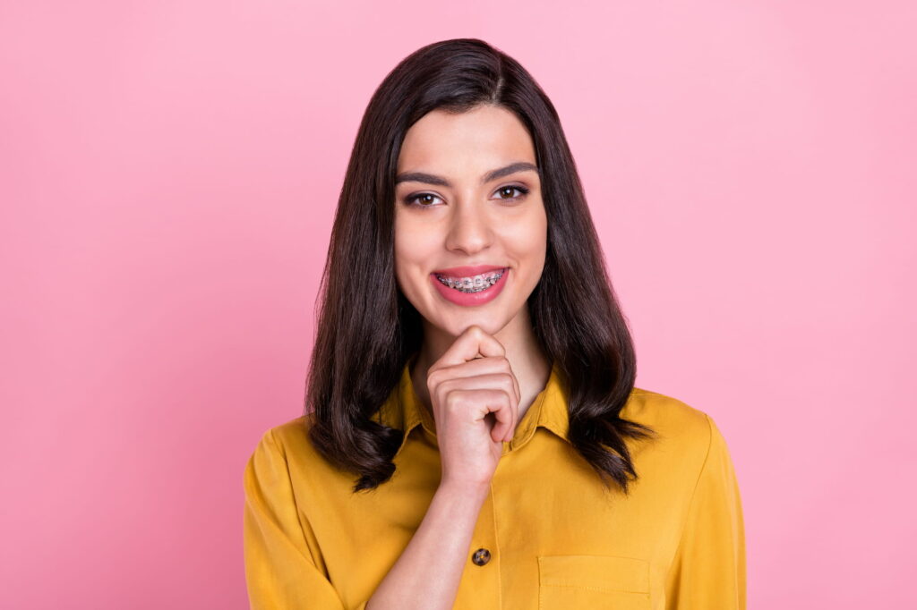 A woman shows off her braces and the sparkling smile behind them.
